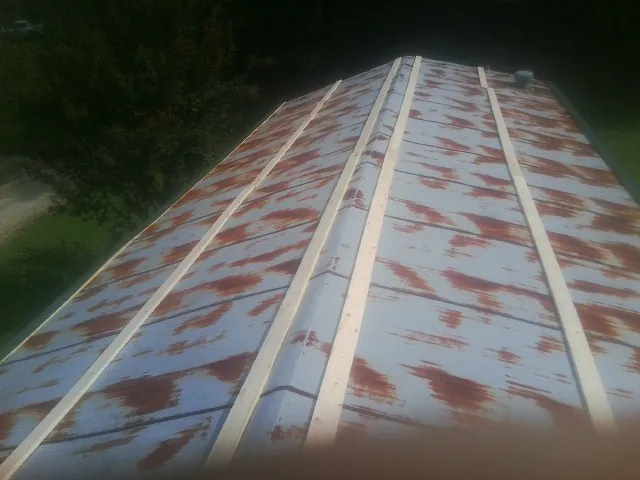 Rusted metal roof panels with new wood purlins before replacement — Storm Damage Roof Repair in Batavia by Roofing Brothers
